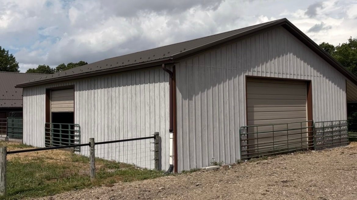 Repainted pole barn exterior with light gray siding and brown trim