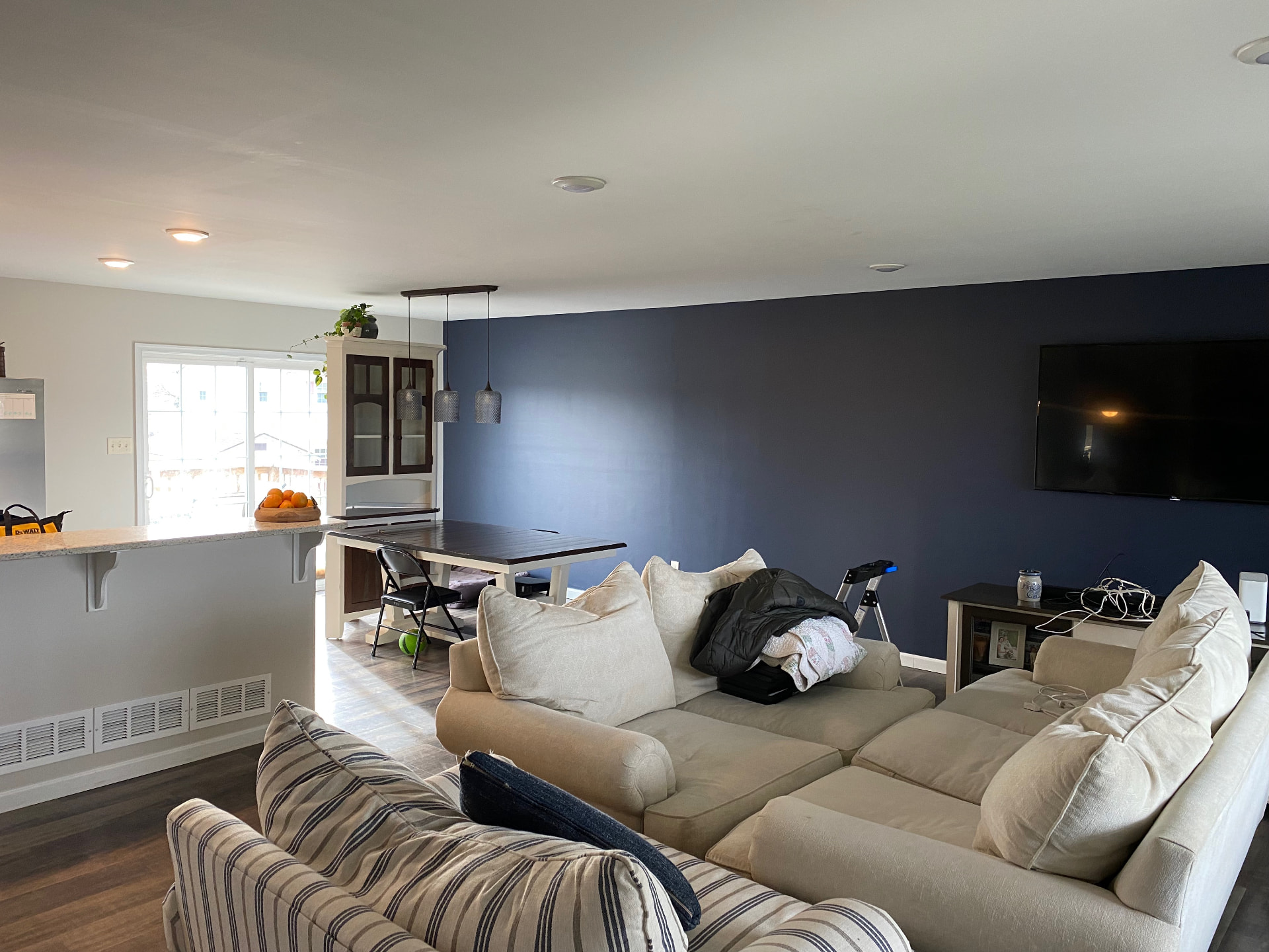 Interior repaint with blue accent wall in open living and dining space